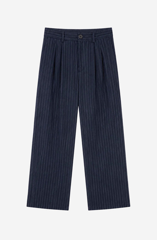 Pantalón Belle Époque navy de raya diplomática blanca con pinzas delanteras, pernera ancha y detalle Kaotiko Society trasero.
