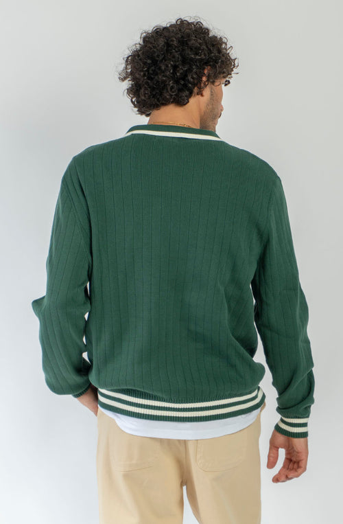 Polo unisex de punto verde de canalé con cuello de botones, detalles en contraste color crudo y bordado Kaotiko en el pecho.
