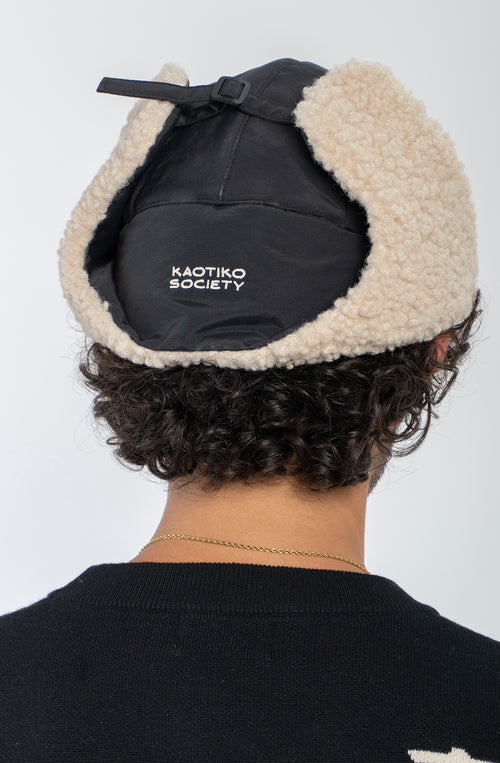 Gorro Trapper Negro Kaotiko con borreguito beige y orejeras.