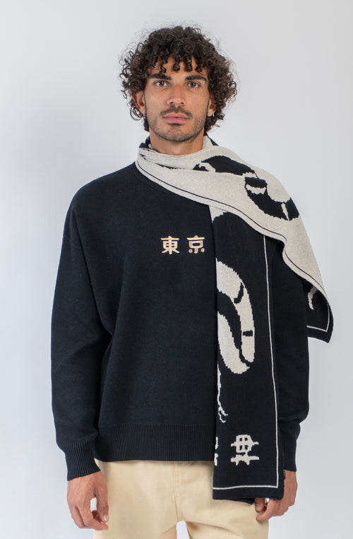 Bufanda reversible de punto en negro y crudo con diseño de serpiente de gran formato.