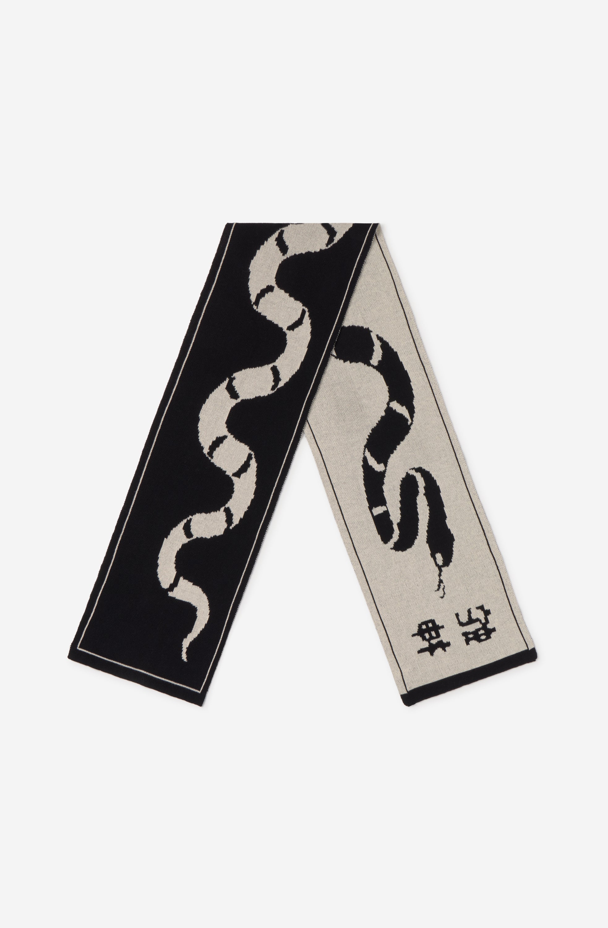 Bufanda reversible de punto en negro y crudo con diseño de serpiente de gran formato.