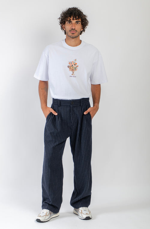 Pantalón Belle Époque navy de raya diplomática blanca con pinzas delanteras, pernera ancha y detalle Kaotiko Society trasero.