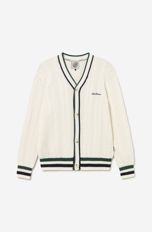 Cardigan de punto trenzado color marfil con cuello de pico, botones y detalles en verde y azul marino.