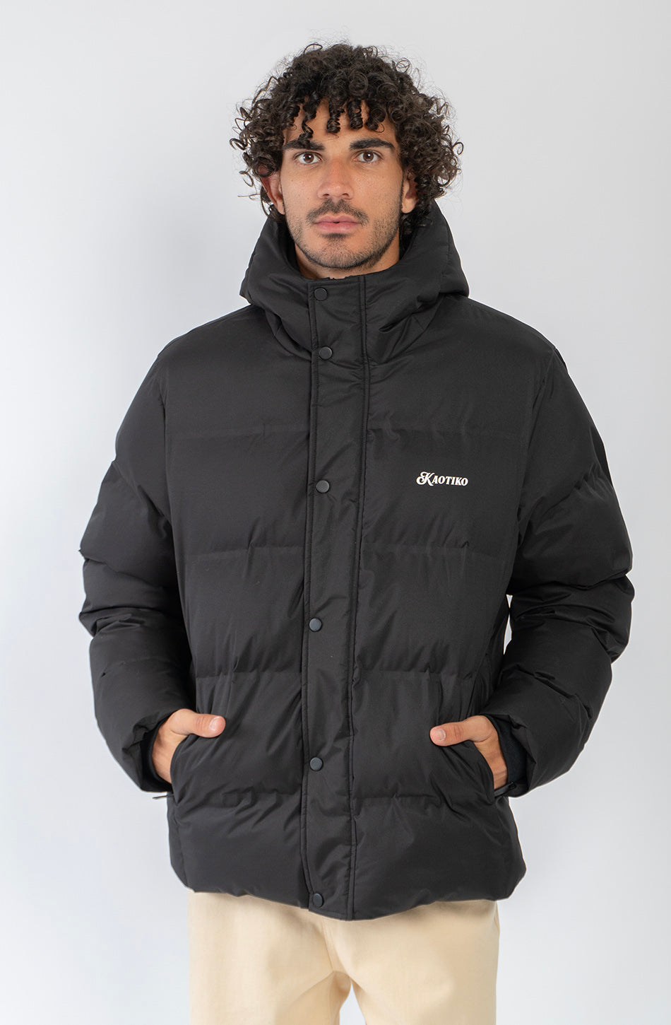 Chaqueta acolchada azul marino oscuro con capucha, cierre frontal y logo Kaotiko bordado en el pecho.
