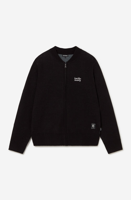 Jersey unisex de punto negro con cremallera, bordado Kaotiko Society en el pecho y gráfico jacquard de flores azules con mensaje Bad Romance en la espalda.