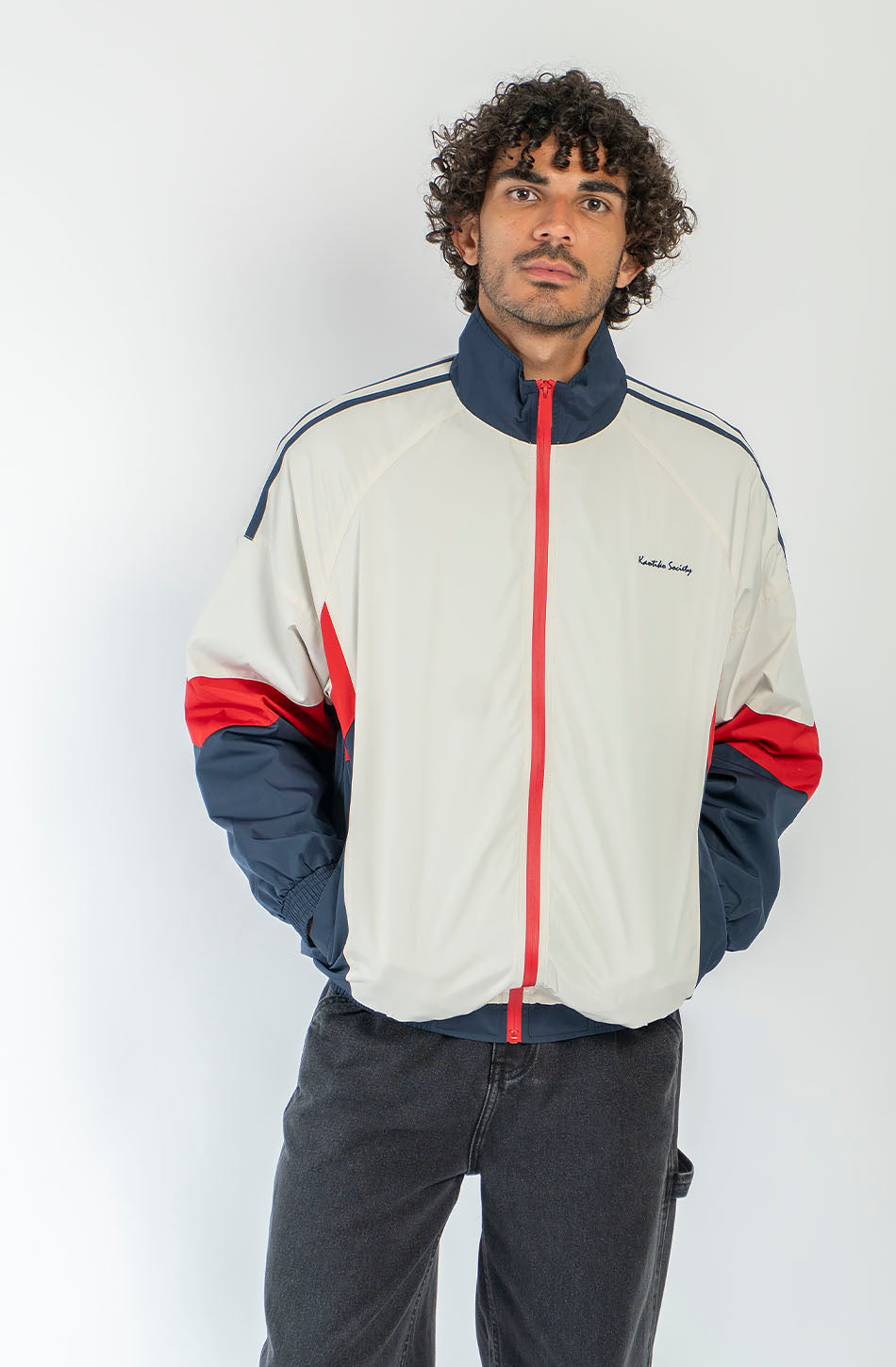 Chaqueta Retro Ski en marfil, rojo y azul marino con diseño color block, cremallera roja y logo Kaotiko Society.
