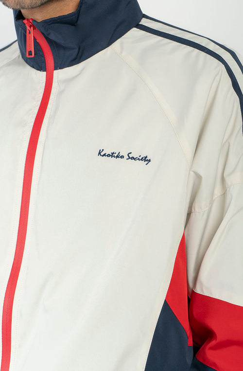 Chaqueta Retro Ski en marfil, rojo y azul marino con diseño color block, cremallera roja y logo Kaotiko Society.