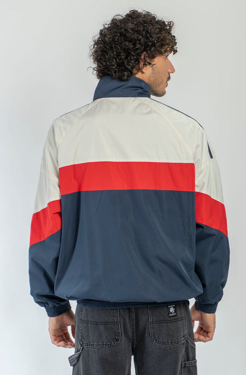 Chaqueta Retro Ski en marfil, rojo y azul marino con diseño color block, cremallera roja y logo Kaotiko Society.