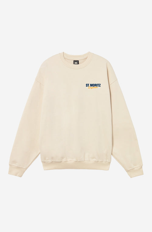 Sudadera oversize unisex de algodón orgánico color crudo con gráfico St. Moritz Engadin en el pecho e ilustración vintage de esquiadoras en la espalda.