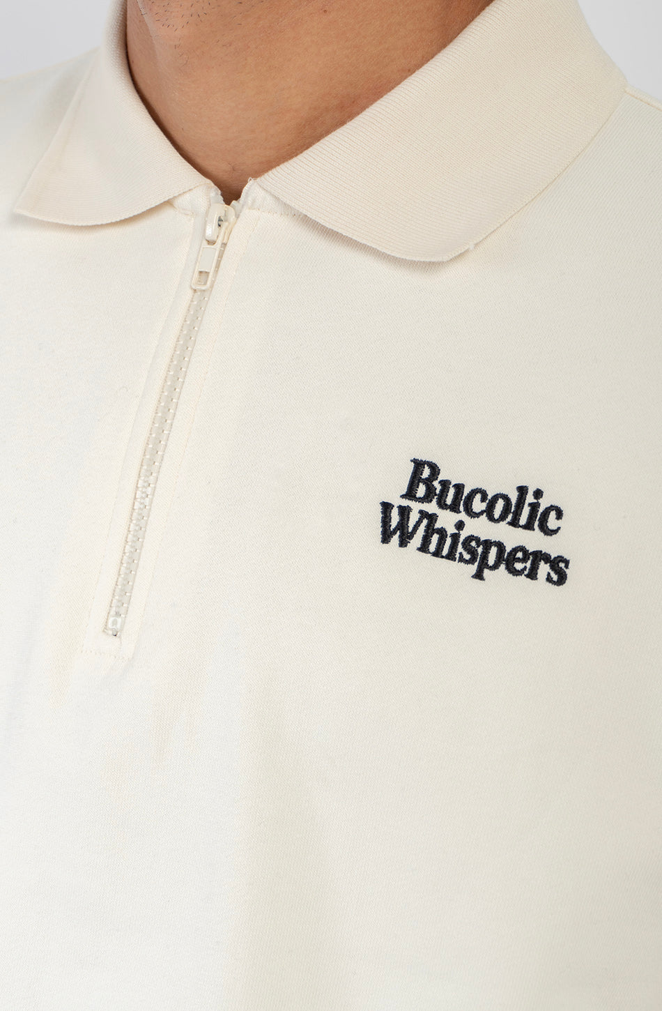 Sudadera zipper ivory con cuello polo, logo Bucolic Whispers en el pecho y bordado floral en la espalda.