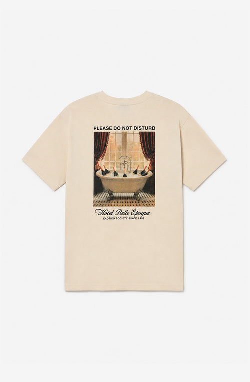 Camiseta Regular No Disturb Organic ivory con mensaje Please Do Not Disturb y gráfico Hotel Belle Époque en la espalda.