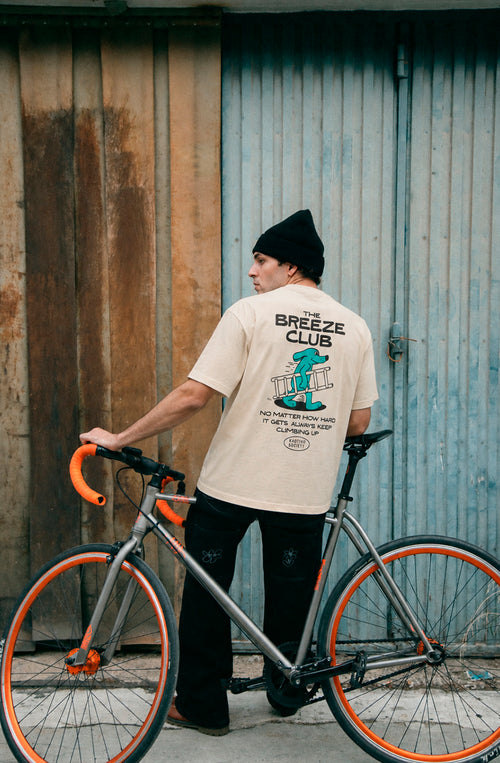 Camiseta unisex regular color ivory con gráfico Kaotiko Society en el pecho y estampado Climbing Rat en la espalda.